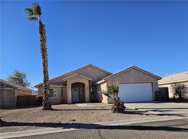 single story home with an attached garage, driveway, fence, and stucco siding