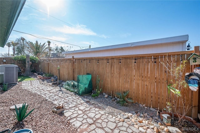 view of yard with central AC unit and a fenced backyard