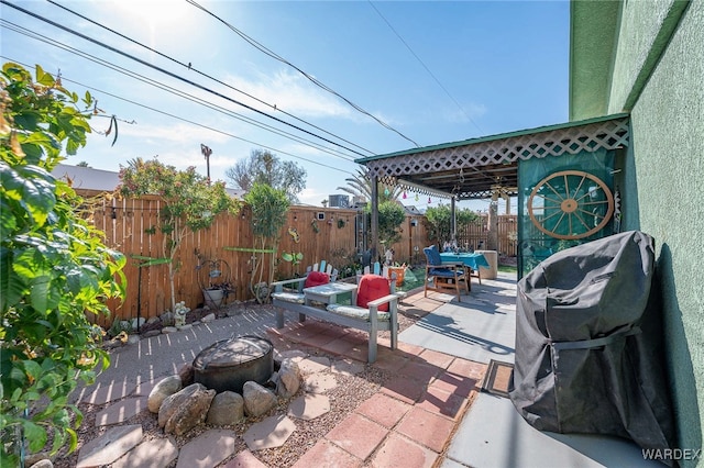 view of patio featuring a fenced backyard and a fire pit