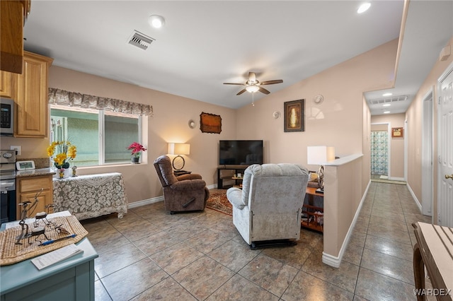 living area with lofted ceiling, baseboards, visible vents, and a ceiling fan