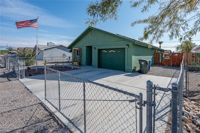 exterior space featuring a garage, fence private yard, driveway, and stucco siding