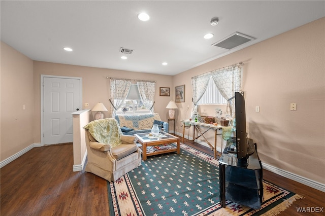 sitting room with dark wood-style floors, visible vents, and baseboards