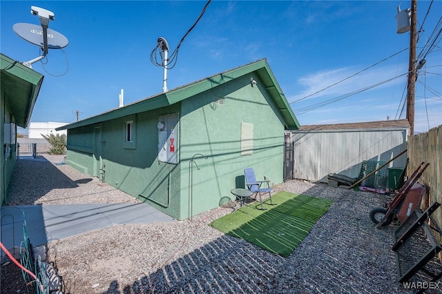 view of side of home with fence and stucco siding