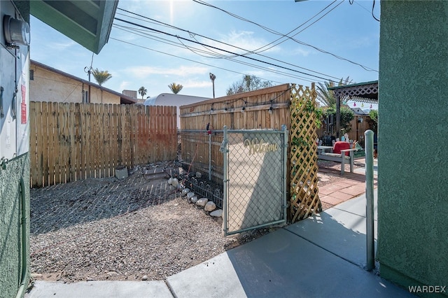 view of gate with a patio area and a fenced backyard