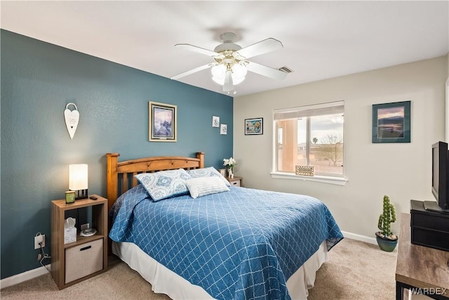 carpeted bedroom featuring a ceiling fan, visible vents, and baseboards