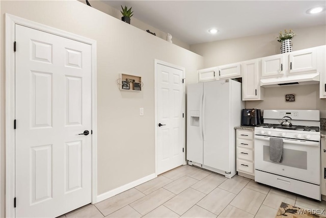 kitchen featuring under cabinet range hood, white cabinets, white appliances, and baseboards