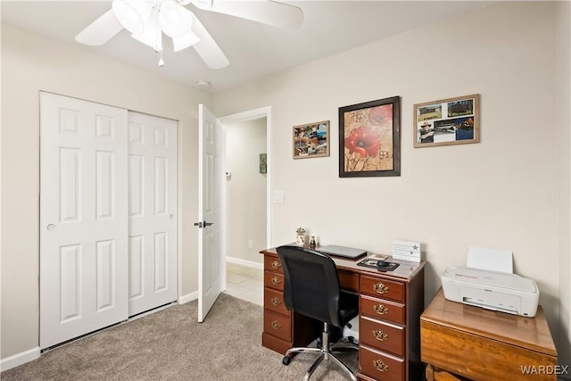 carpeted home office featuring baseboards and ceiling fan