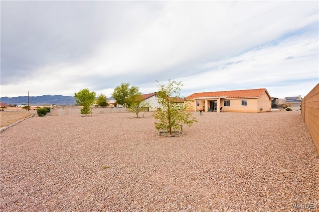 view of yard featuring fence and a mountain view