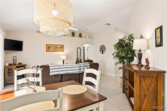 dining area featuring visible vents, lofted ceiling, and baseboards