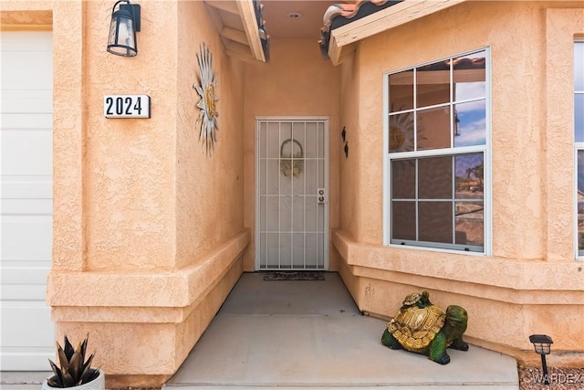 view of exterior entry featuring stucco siding