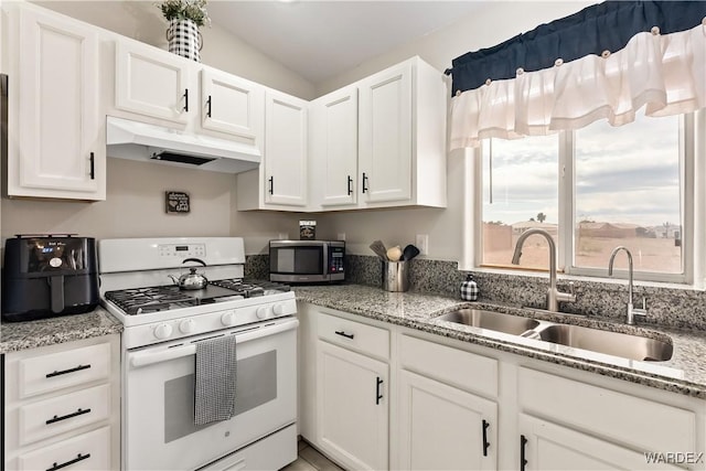 kitchen featuring white range with gas cooktop, under cabinet range hood, stainless steel microwave, a sink, and white cabinets