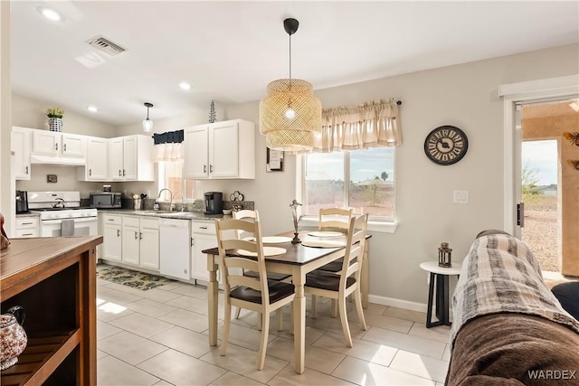 kitchen with visible vents, a sink, under cabinet range hood, white cabinetry, and white appliances