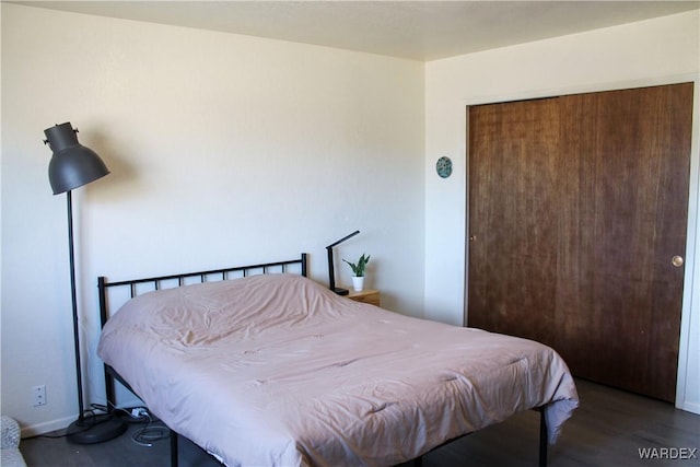 bedroom with a closet, baseboards, and wood finished floors