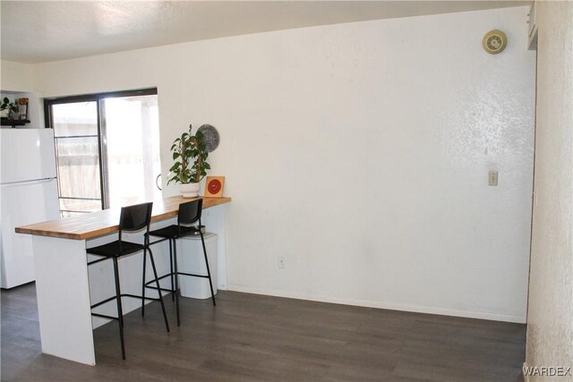 office space with dark wood-type flooring and baseboards