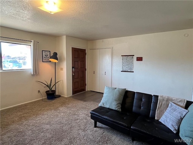 unfurnished living room featuring carpet floors, a textured ceiling, and baseboards