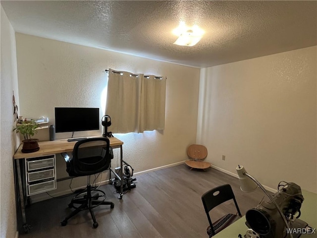 office area featuring a textured ceiling, a textured wall, wood finished floors, and baseboards