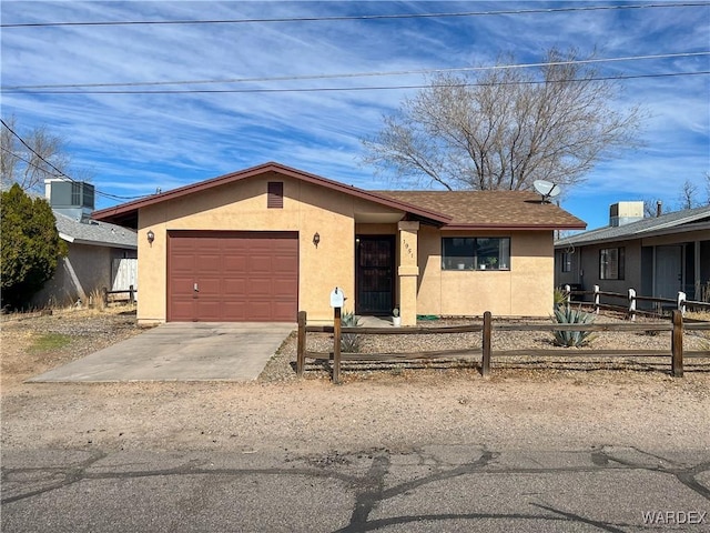 single story home with concrete driveway, fence, an attached garage, and stucco siding