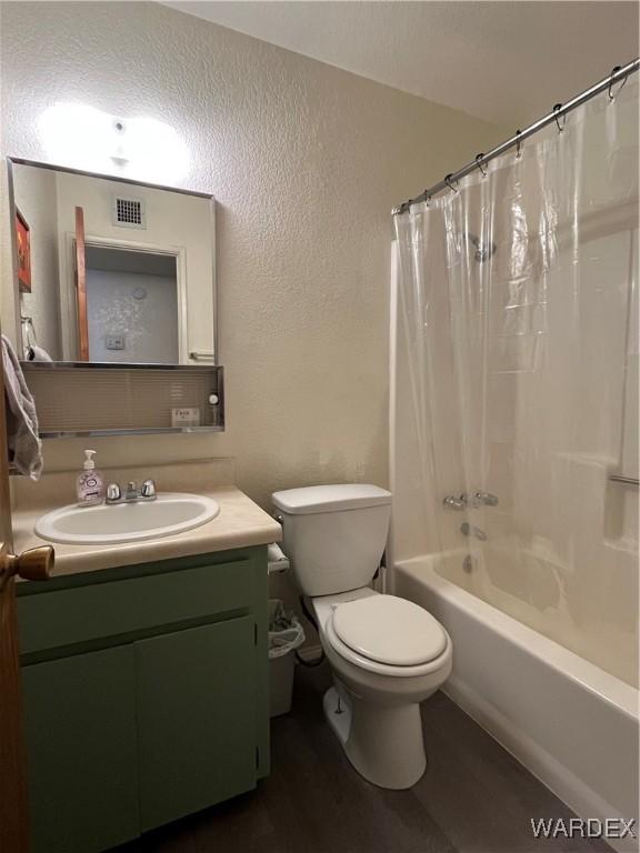 full bath featuring visible vents, a textured wall, toilet, shower / bathtub combination with curtain, and vanity