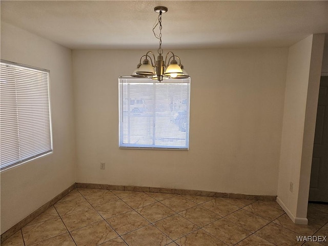 unfurnished dining area featuring light tile patterned floors, baseboards, and a chandelier