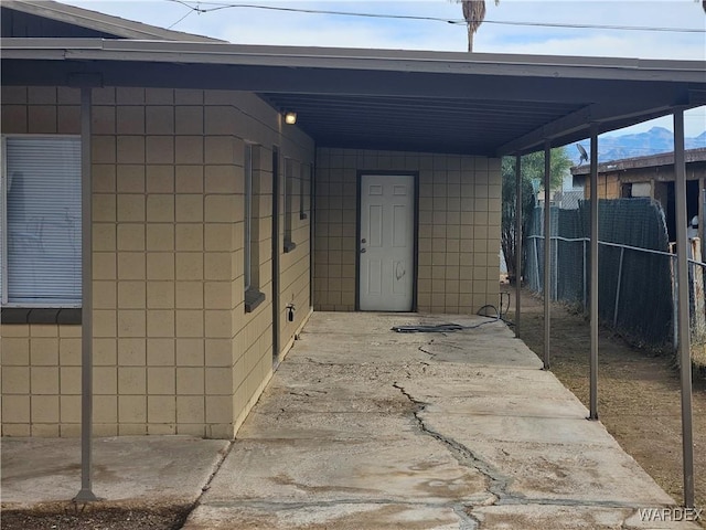 exterior space with an attached carport and fence