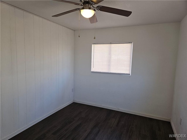 unfurnished room with dark wood finished floors and baseboards