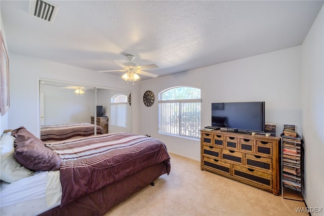 carpeted bedroom with visible vents, a ceiling fan, and baseboards