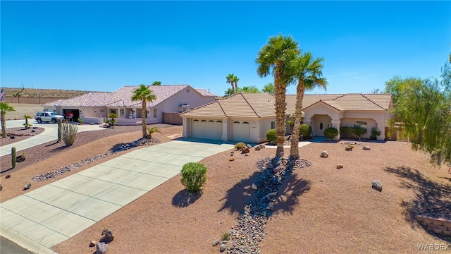 view of front of home with stucco siding, a tile roof, an attached garage, and concrete driveway