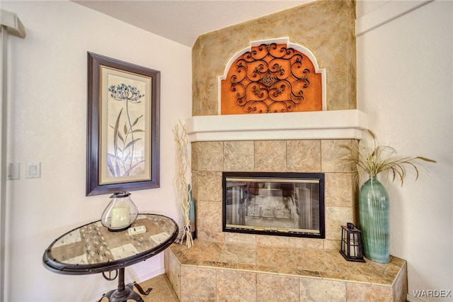interior details with a tile fireplace and baseboards