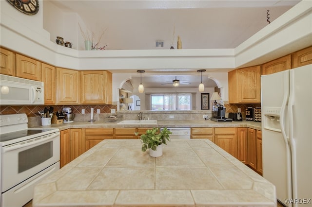 kitchen with backsplash, a sink, arched walkways, white appliances, and a center island
