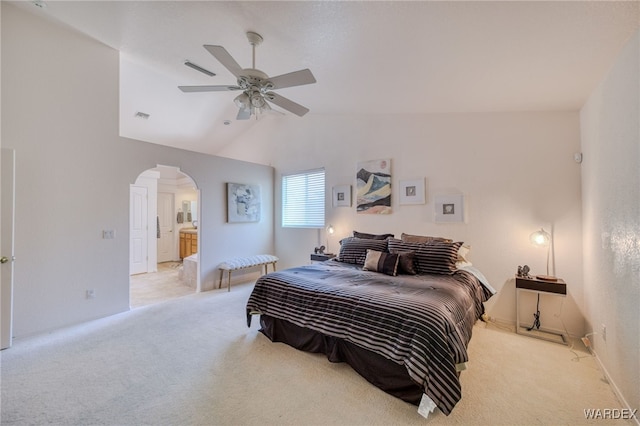 bedroom featuring visible vents, arched walkways, light colored carpet, and vaulted ceiling