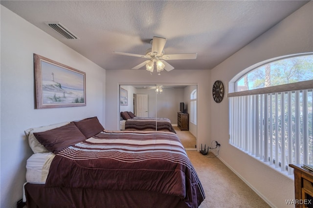 bedroom with visible vents, light carpet, a closet, baseboards, and ceiling fan