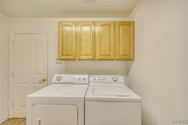 laundry room with cabinet space and washing machine and clothes dryer