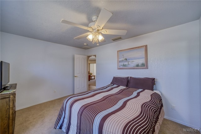 carpeted bedroom with a ceiling fan, visible vents, and a textured ceiling
