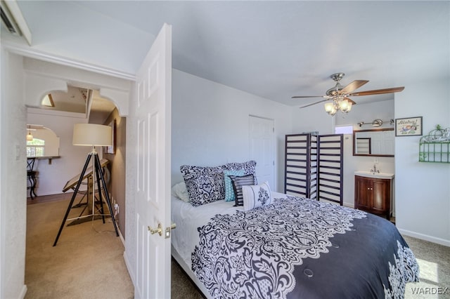 bedroom with arched walkways, carpet, baseboards, and ceiling fan