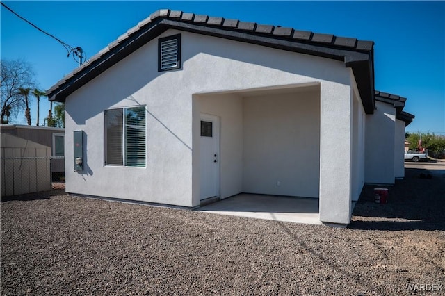 back of house with a patio area, fence, and stucco siding