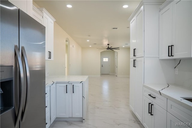 kitchen featuring light stone countertops, marble finish floor, white cabinets, and stainless steel fridge with ice dispenser