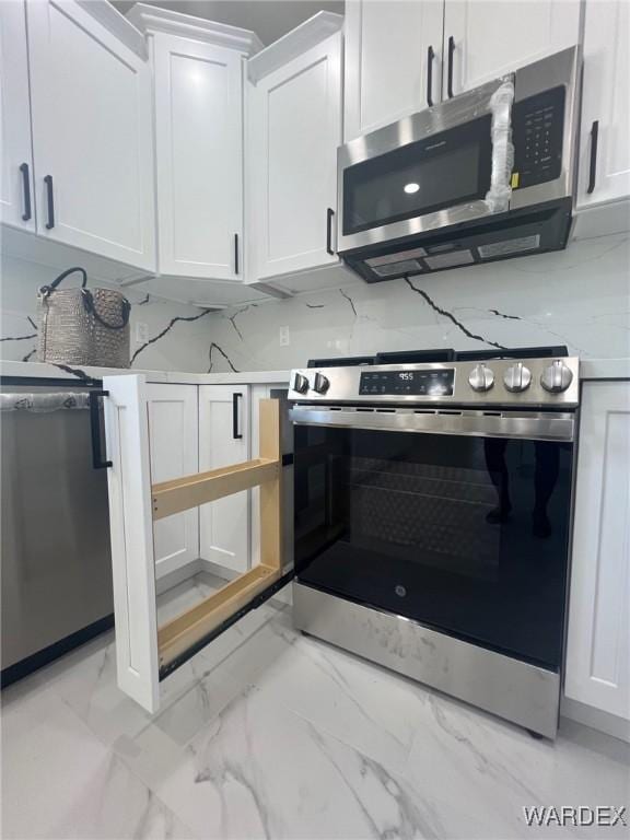 kitchen featuring marble finish floor, stainless steel appliances, white cabinetry, and light stone countertops