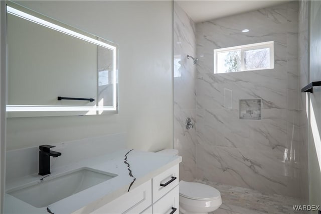 full bathroom with toilet, a marble finish shower, and vanity