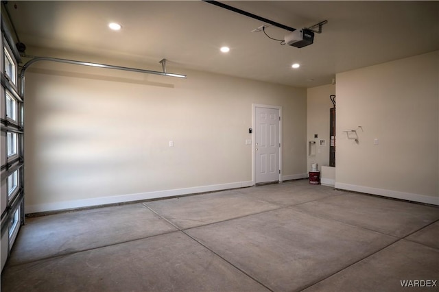 garage featuring a garage door opener, recessed lighting, and baseboards