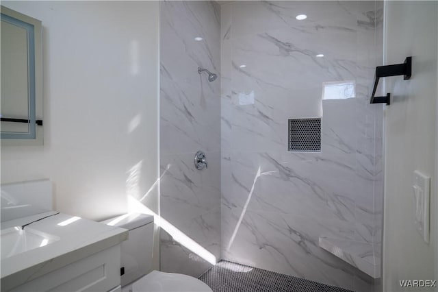 full bath featuring toilet, a marble finish shower, and vanity