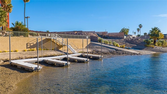 dock area with a water view and fence