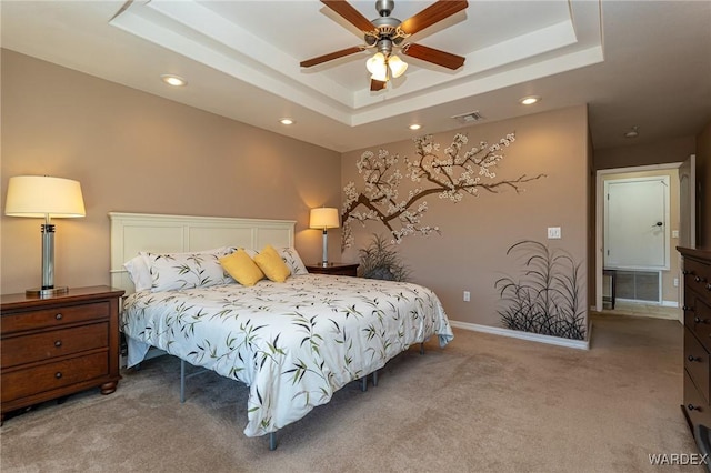 bedroom featuring a tray ceiling, recessed lighting, light colored carpet, visible vents, and baseboards