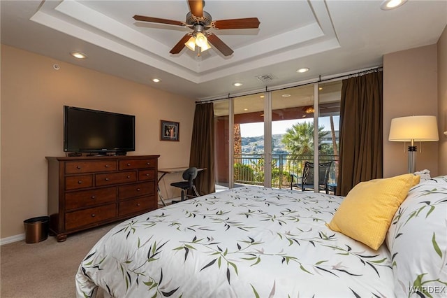 bedroom with light carpet, visible vents, baseboards, access to outside, and a raised ceiling