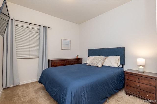 bedroom with baseboards and light colored carpet