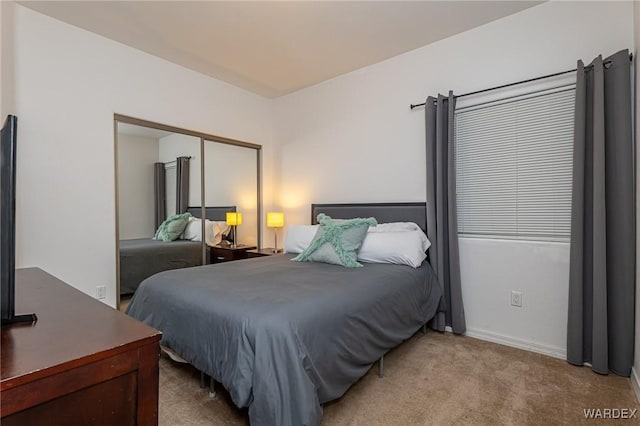 bedroom with baseboards, a closet, and light colored carpet