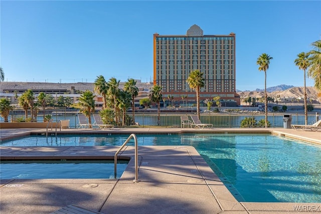 view of swimming pool with fence and a mountain view