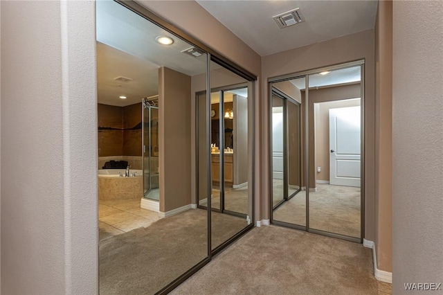 interior space with light colored carpet, visible vents, and baseboards