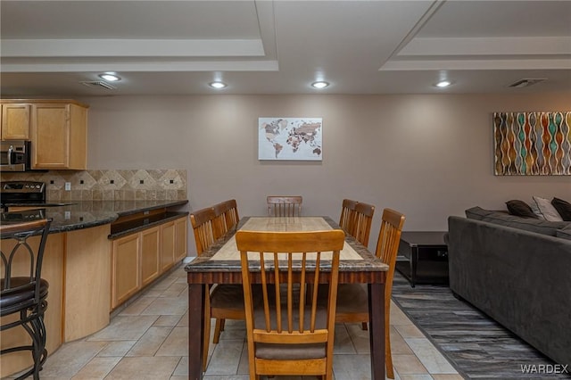 dining area featuring recessed lighting, a raised ceiling, and visible vents