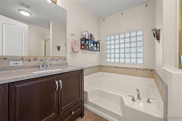 4393 S Colorado Rd, Fort Mohave, AZ 86426 - bathroom with tile patterned flooring, vanity, backsplash, visible vents, and a garden tub
