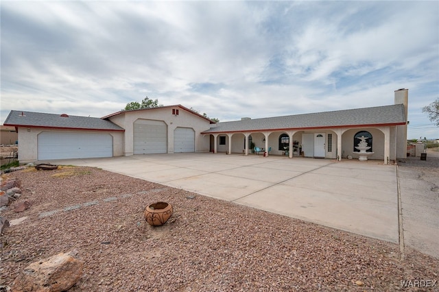 4393 S Colorado Rd, Fort Mohave, AZ 86426 - mediterranean / spanish house featuring an attached garage, stucco siding, a chimney, and concrete driveway